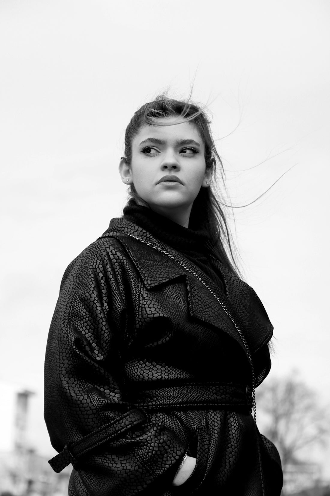 A woman in a black coat is posing for a picture