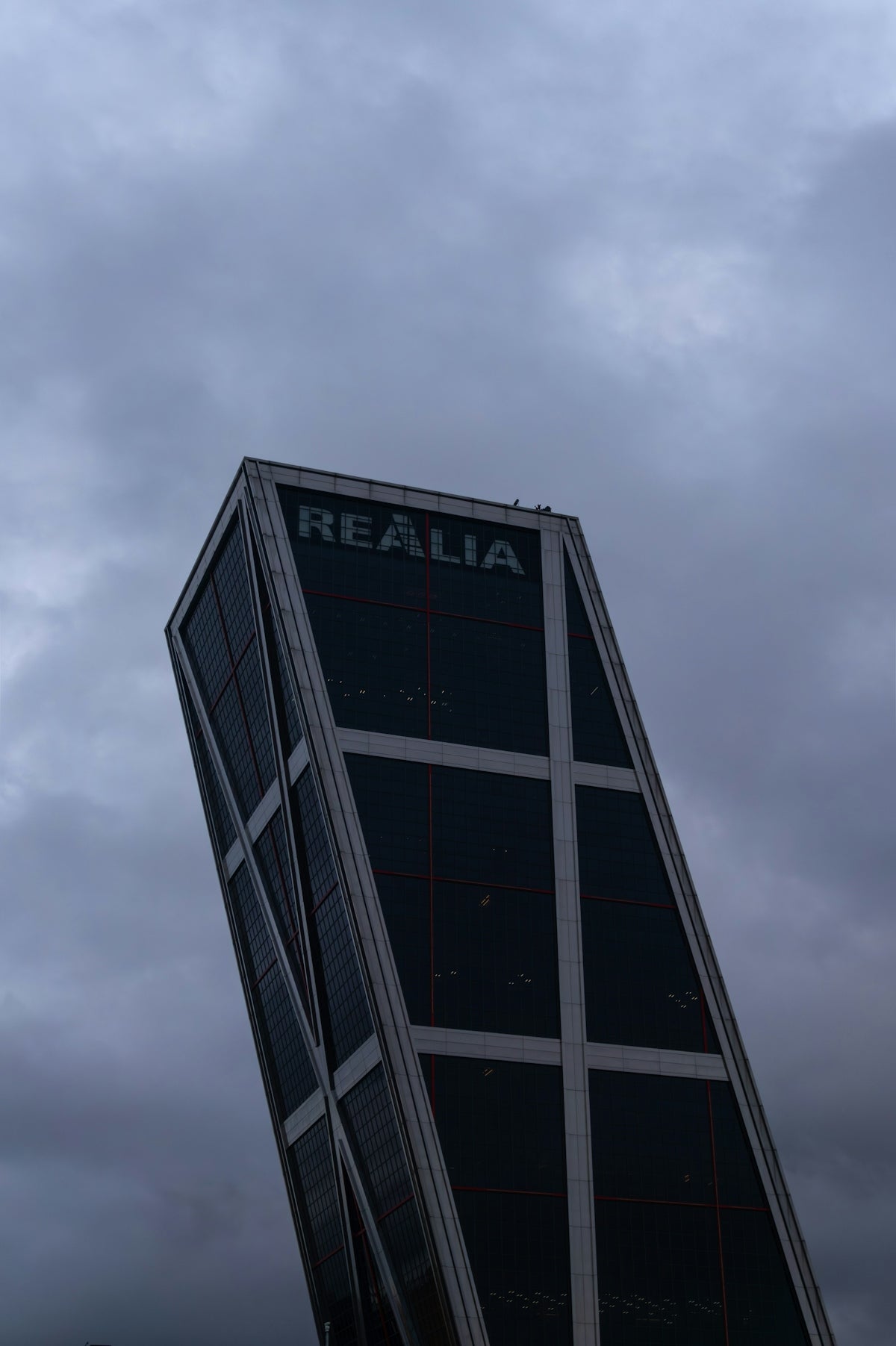 The tilting realia building against a cloudy sky.