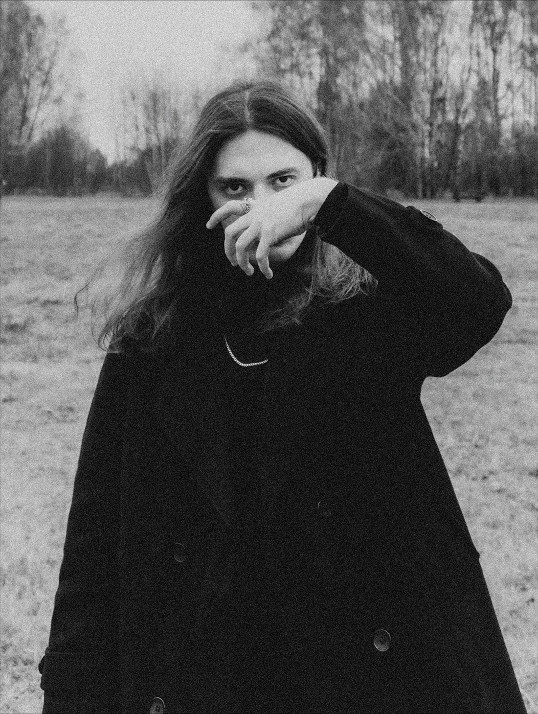 A person with long hair covers their face