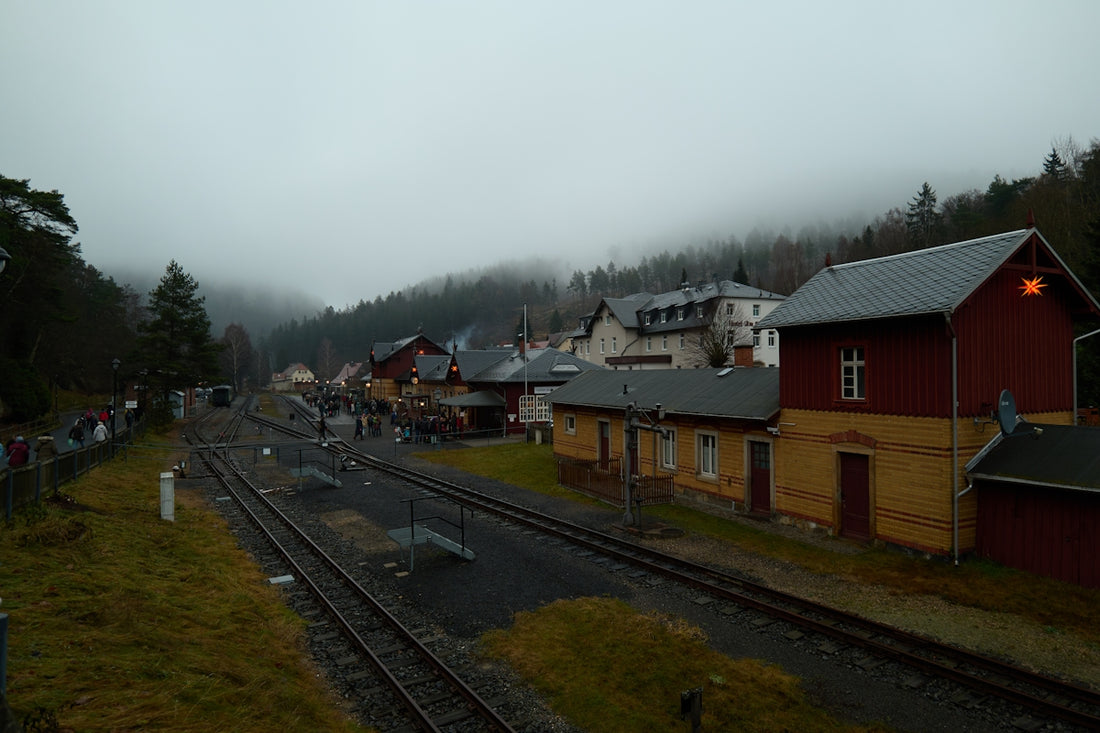 A misty train station with buildings and tracks