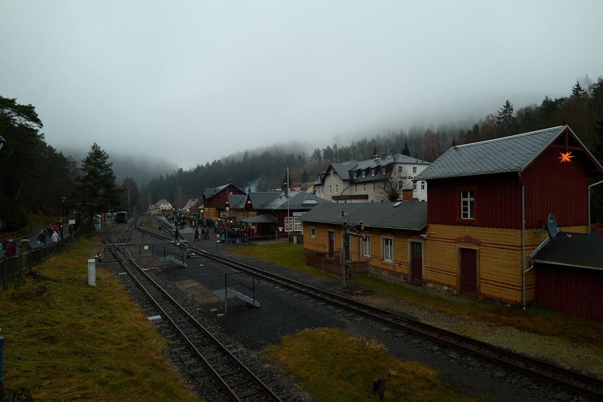 A misty train station with buildings and tracks